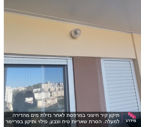 חלון זכוכית עם תריסים סגורים ומנורה על הקיר
